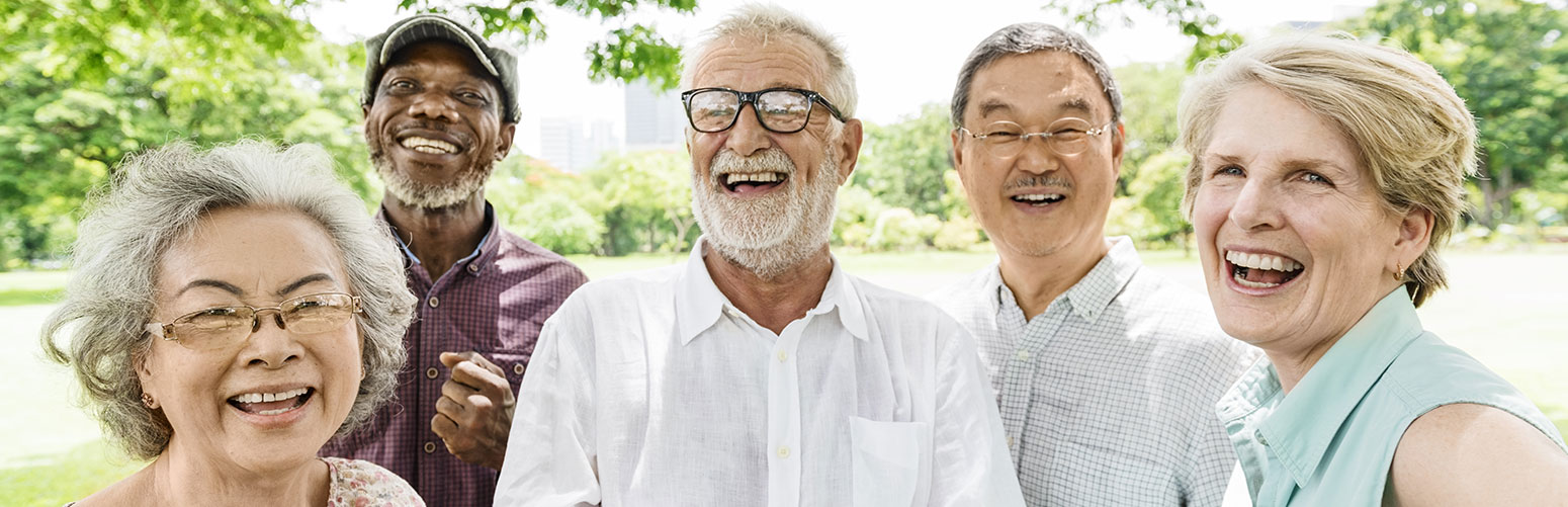 group of elderly friends laughing and smiling at the camera